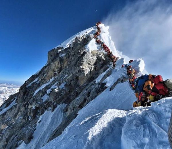 行登山者等待到达珠穆朗玛峰的顶峰